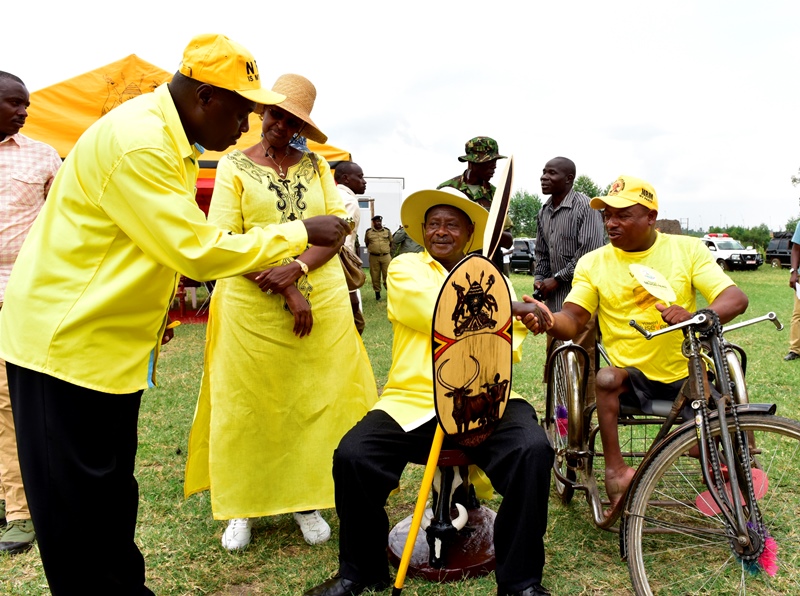 President Museveni receives a chair, shield and spear designed by Bosco Tumwine (in wheelchair) as Firts Lady Janet looks on during a rally in Bwizibwera, Kashari South, Mbarara yesterday Jan 12.