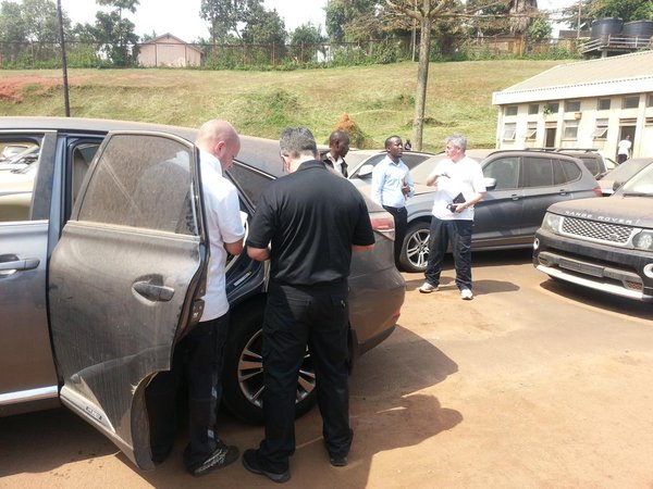 Interpol officials inspect one of the stolen cars at the URA offices in Kampala