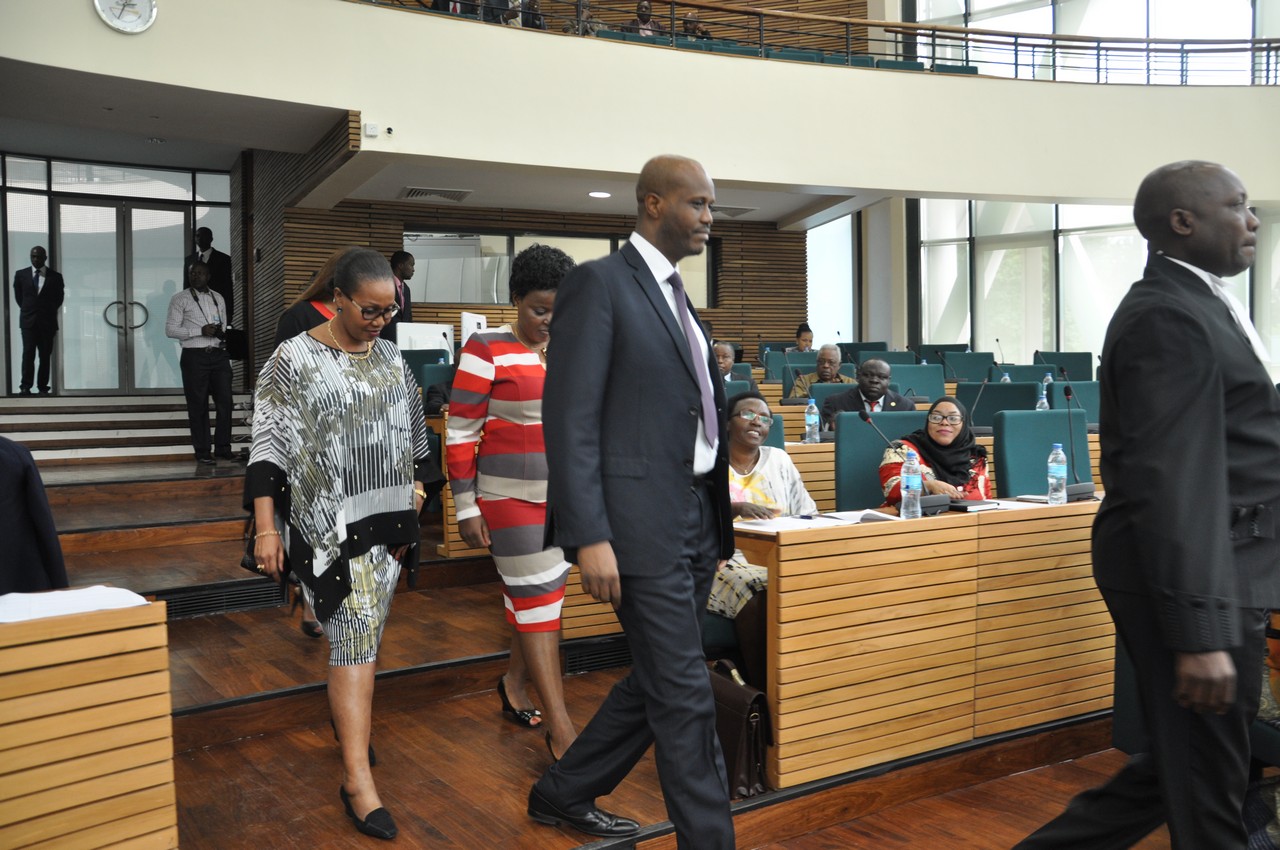The EAC Secretary General, Hon Amb Liberat Mfumukeko is led in to the House to take the Oath of Allegiance by the Clerk to the Assembly, Kenneth Madete. At back is Hon Hafsa Mossi and Hon Isabelle Ndahayo