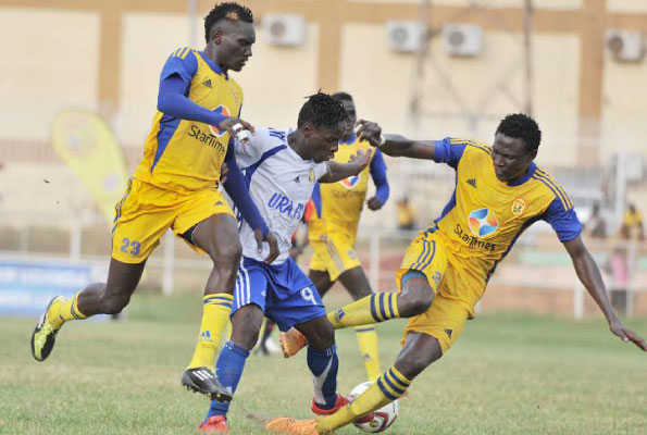 Robert Ssentongo (C) battles Joseph Ochaya and Lawrence Kasadha of KCCA during their Uganda Premier League encounter on February 23 at Nakivubo Stadium