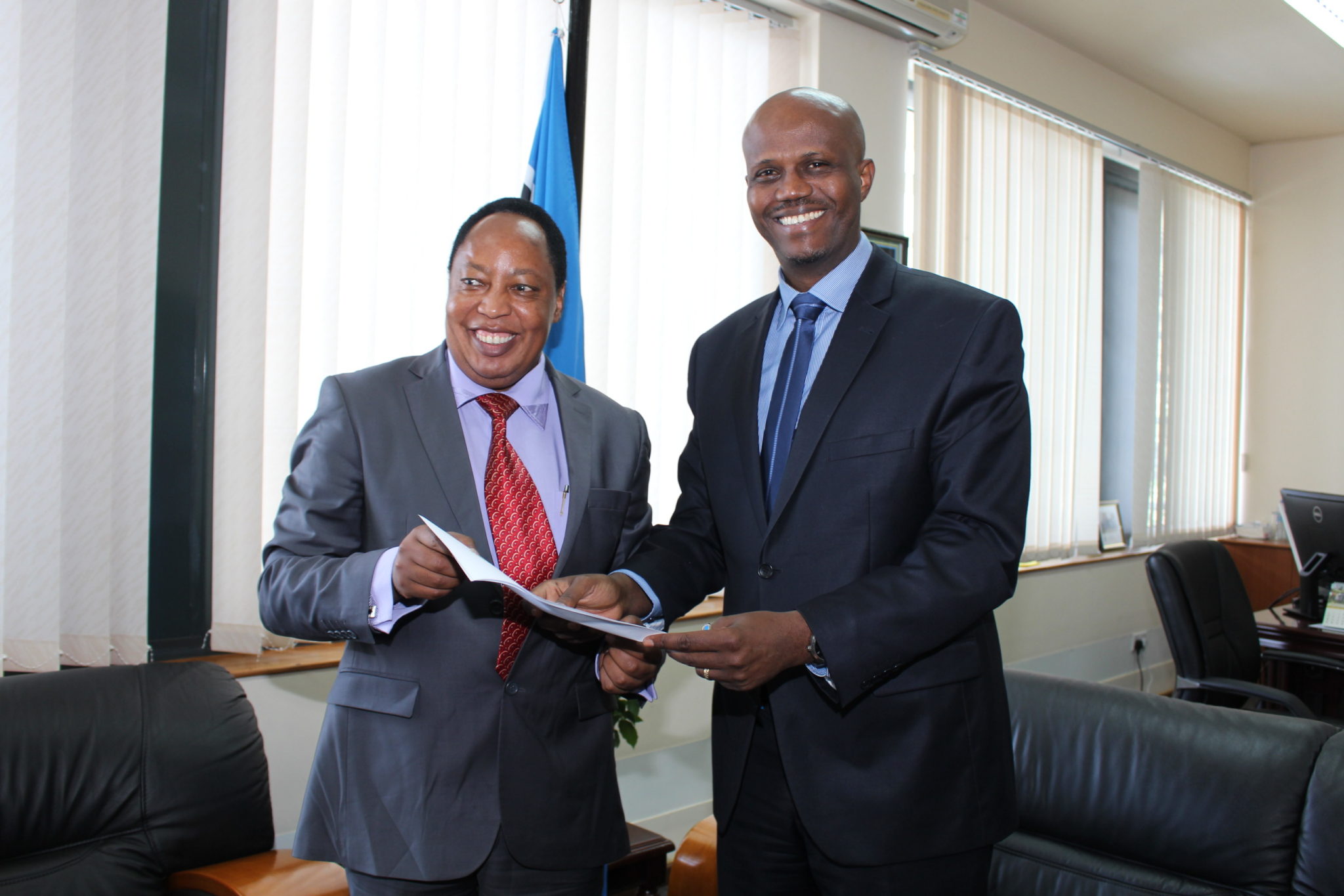 Dr Matano receives the signed copy of the Oath from the Secretary General, Amb Liberat Mfumukeko