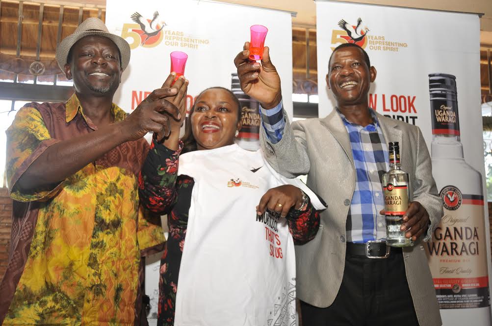 (L-R) Moses Matovu, Joanitah Kawalya and Herman Ssewanyana, founding members of Afrigo Band in a celebratory toast with their long term partner, Uganda Waragi. 