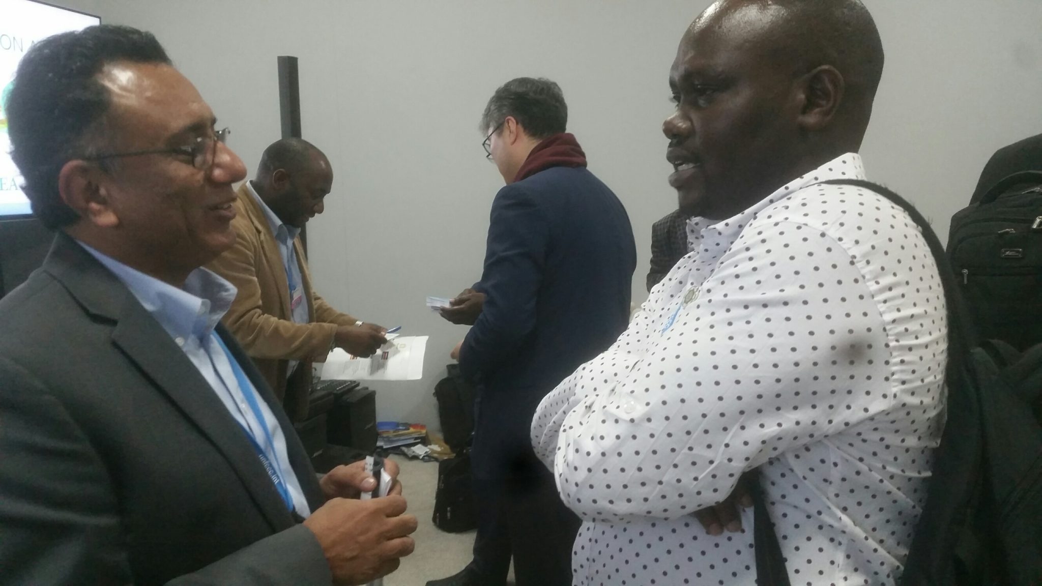 Mr. Ali Raza Rizvi, Programme Manager of Ecosystem Based Adaptation at IUCN (left) chats with Gideon Sanago (right) of Pingos Forum Tanzania at the end of the the EAC side-event at COP in Marrakech.  