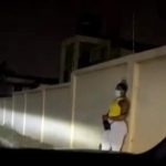 A sex worker masking her face waiting for clients at night in town.