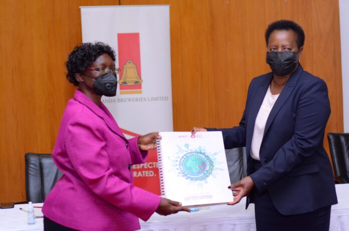 Florence Grace Adongo, Director of Water Resources at the Ministry of Water and Environment receives the EABL Sustainability Report from Jane Karuku, EABL Group MD & CEO