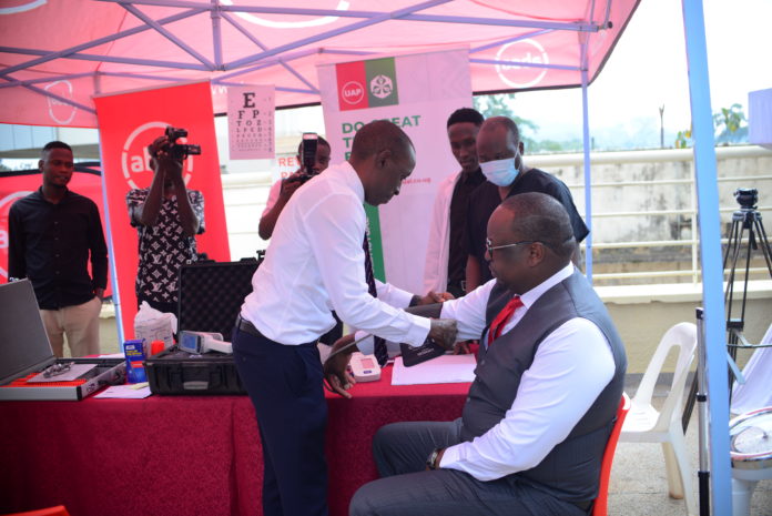 Dr. Paul Kasenene checks Absa MD - Mumba Kalifungwa's blood pressure during the launch