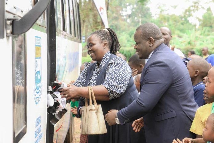 Beatrice Katami Wachaya Head Teacher Nabumali Boarding School with Nakhasanga Ronald Sam, Regional Manager Eastern Equity Bank officially entering the bus